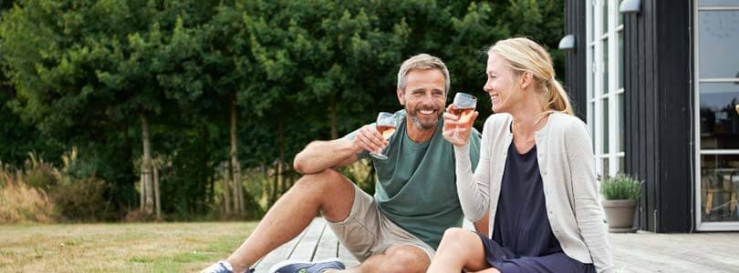 Ehepaar trinken wein am Ferienhaus in Bogense